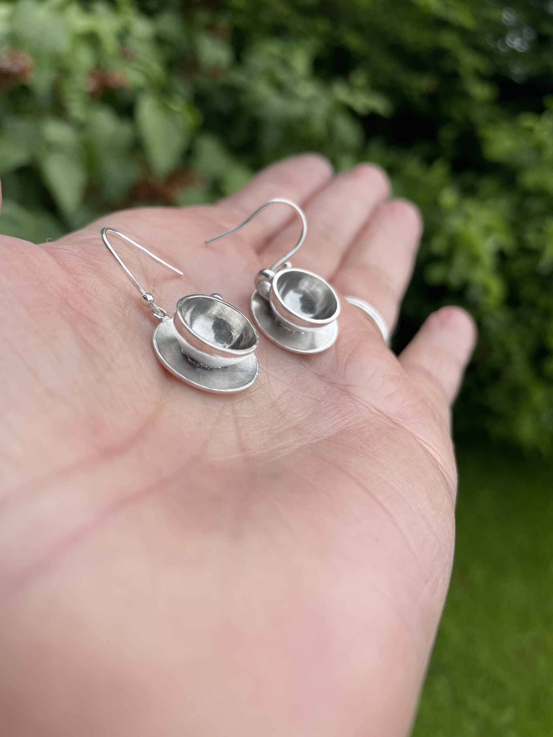 silver coffee cup drop earrings on hand